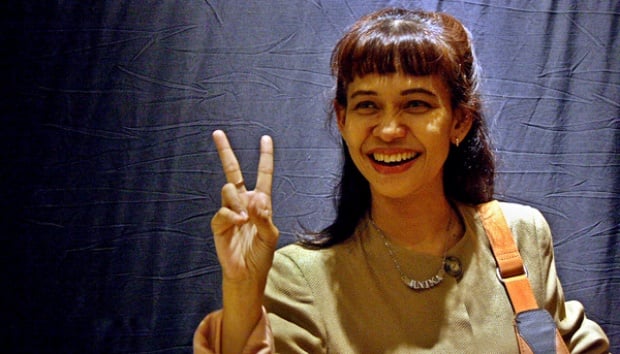 Cewek senyum dengan tanda peace