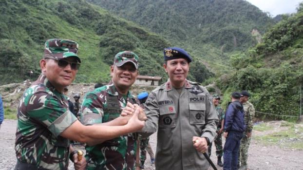 3 TNI berjabat tangan dengan latar belakang gunung